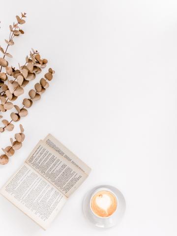 an open book next to a cup of coffee