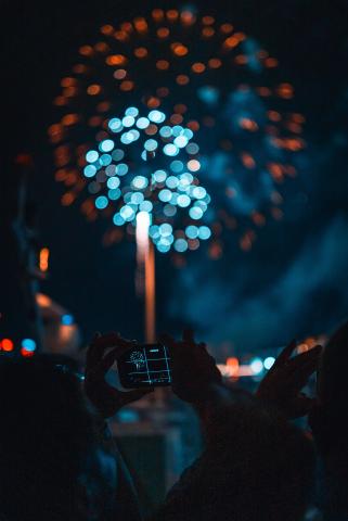 blue and red fireworks bursting apart over a crowd